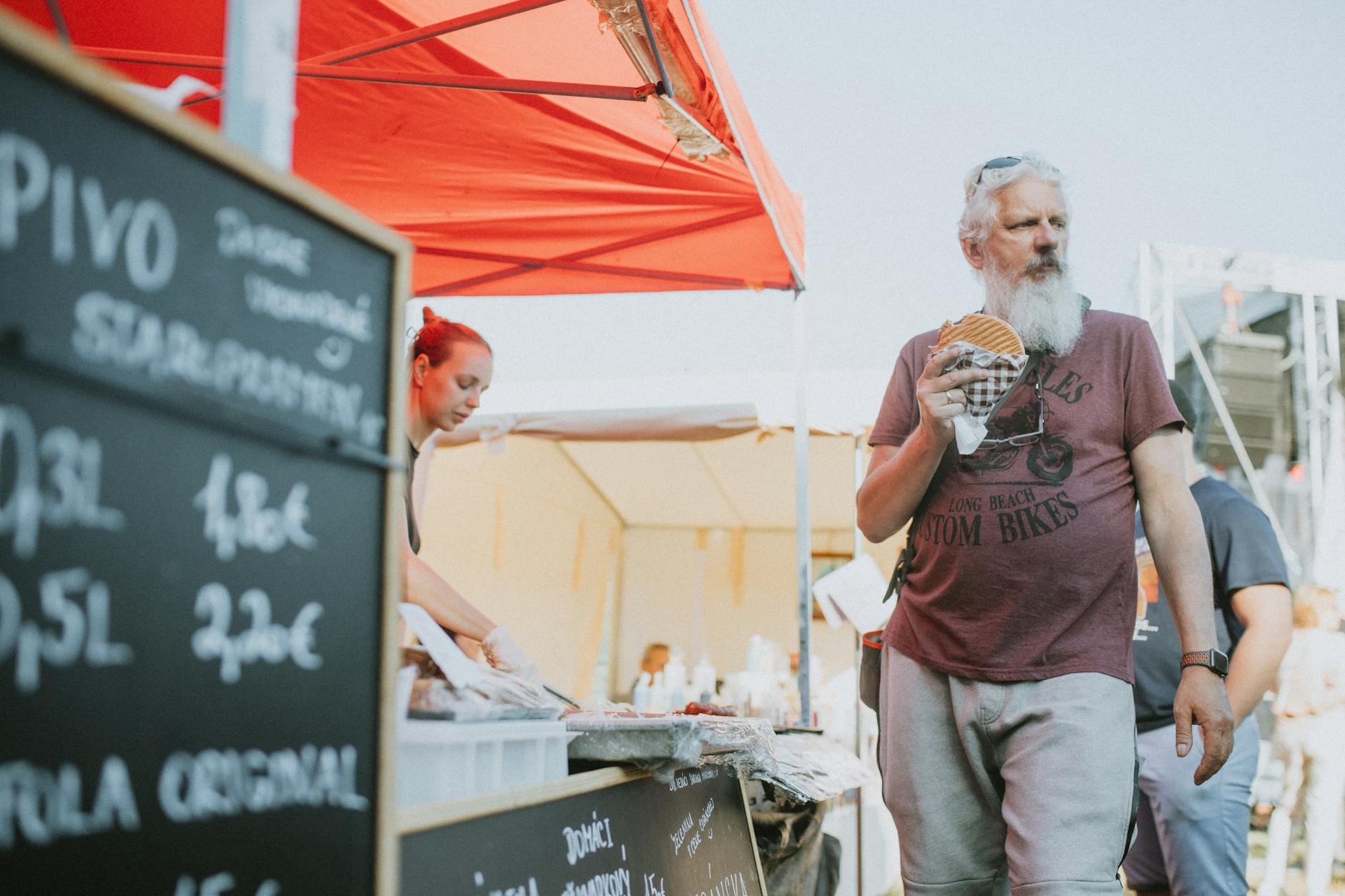 Uśmiechnięci ludzie cieszący się jedzeniem z food trucków w Białymstoku podczas pikniku